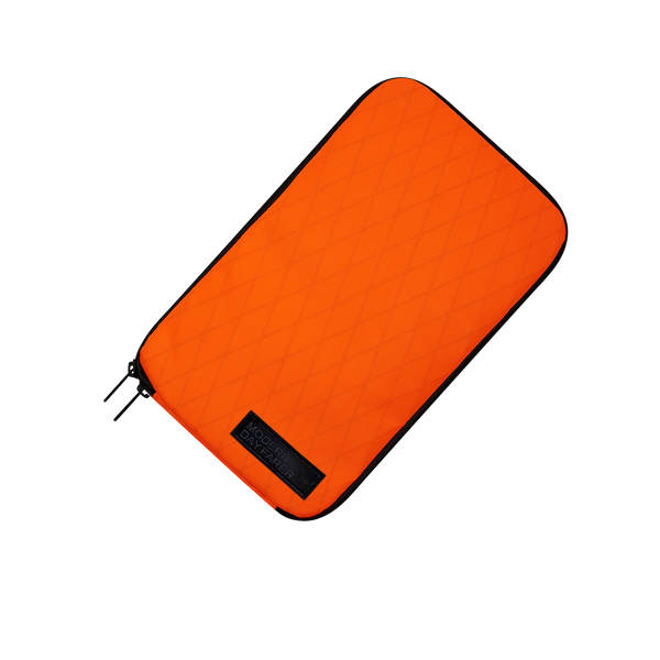 "MODERN DAYFARER Tech Pouch RVX25 - Bright orange color for easy visibility and a pop of color in your bag."
